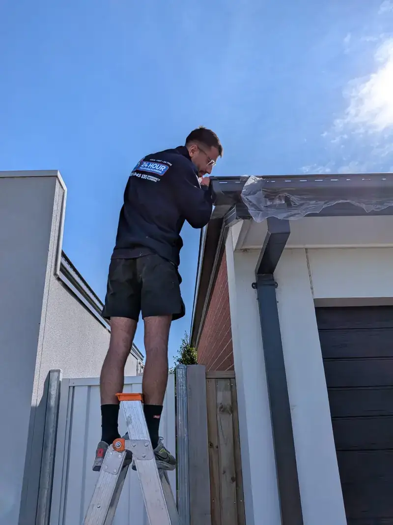 Roof plumber working on gutter in Armadale